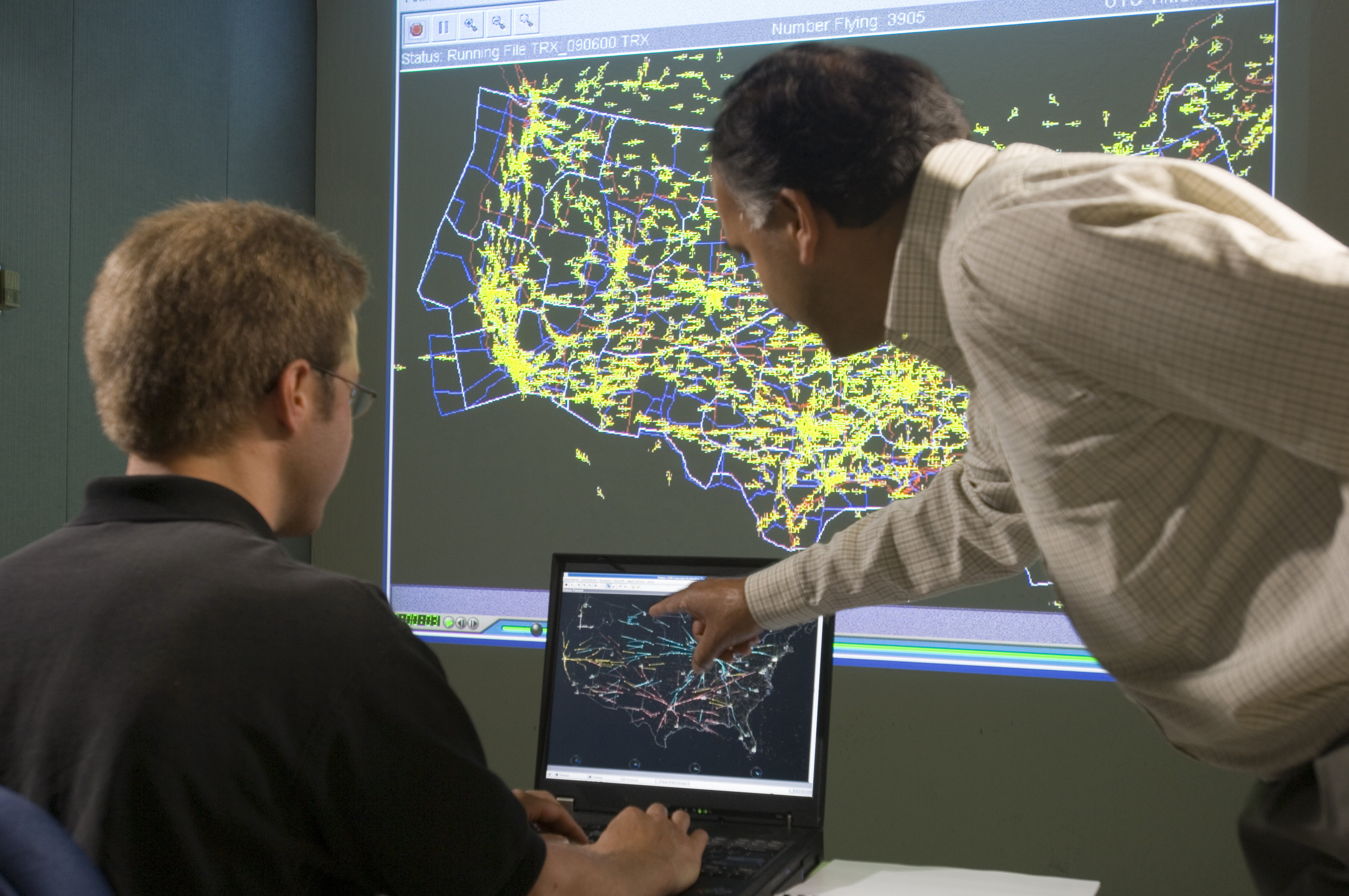 Dr. Shon Grabbe and Kapil Sheth looking at a monitor.