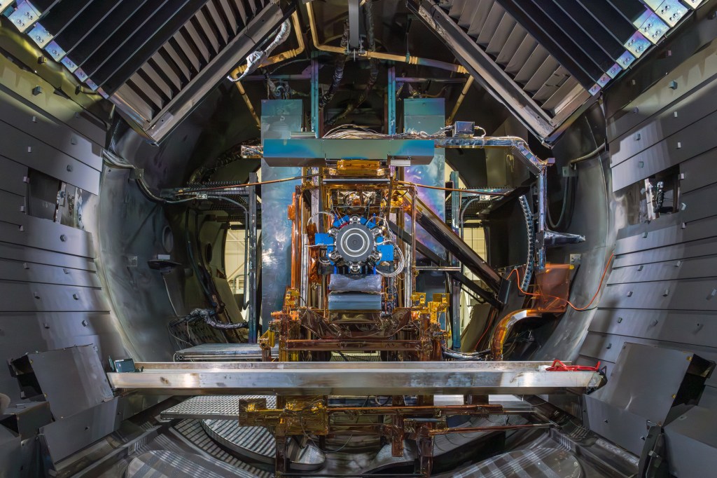A thruster undergoing testing inside a large chamber, showcasing detailed engineering and complex machinery.