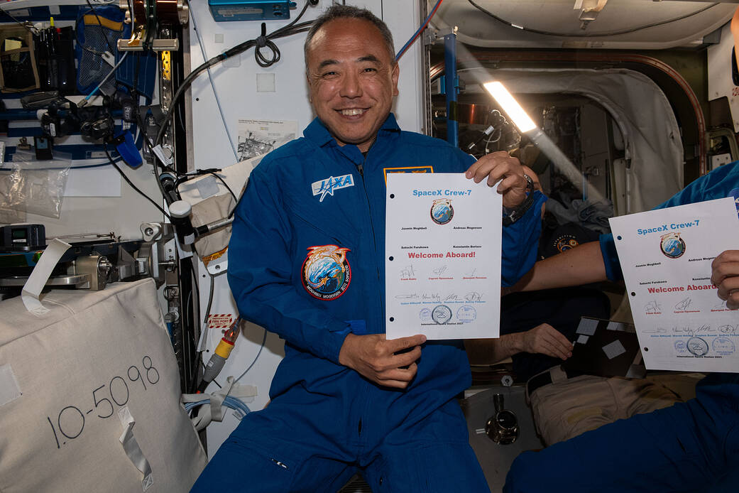 JAXA astronaut and Crew-7 Mission Specialist, Satoshi Furukawa, smiles for a photo while holding a welcome message from the Expedition 69 crew, fol...